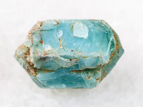 raw crystal of blue apatite gemstone on white