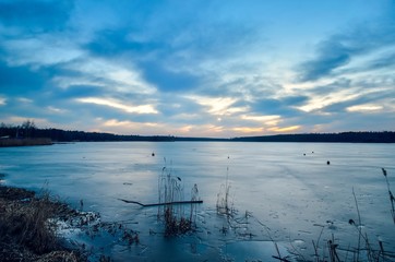 Evening winter landscape. View after sunset over a beautiful lake.