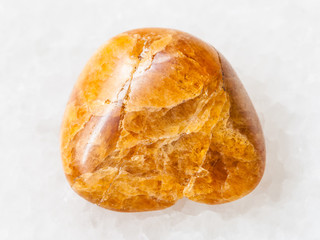 tumbled Clinohumite gemstone on white