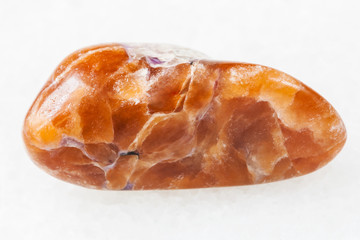 polished tinaksite gemstone on white
