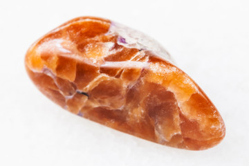 tumbled tinaksite gemstone on white