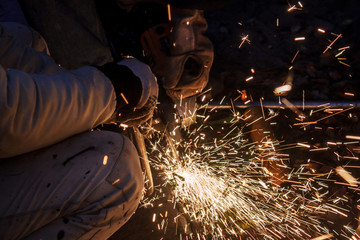 Worker making sparks while welding steel