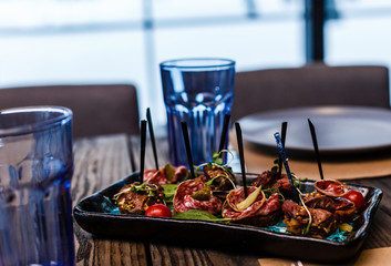 Baked rolls with salami in the form of roses on the table. Horizontal top view
