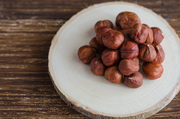 Close up of Peeled organic hazelnut on wooden slab. Healthy and nutritive snack Copy space