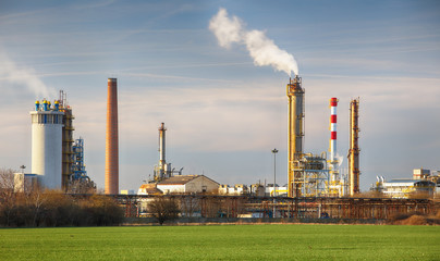 Fototapeta na wymiar Smoking chimneys of a petrochemical factory in an oil refinery