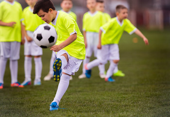 Boy kicking football on the sports field