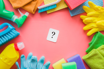 Colorful cleaning set for different surfaces in rooms, kitchen and bathroom. Question mark on pink...