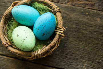 Easter eggs in a basket on a wooden background