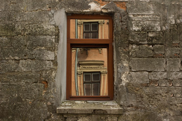 Fototapeta na wymiar Beauty in reflection concept with window in old slum concrete wall in backstreet