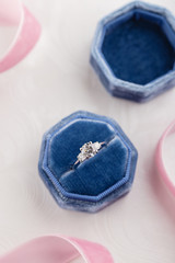 Fototapeta na wymiar White golden wedding ring with diamonds in blue vintage velvet box