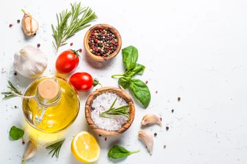 Keuken spatwand met foto Specerijen, kruiden en olijfolie over witte stenen tafel. © nadianb