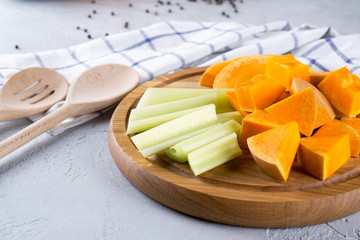 Sliced pumpkin on a wooden board. Home cooking food with pumpkin. Still life in the kitchen