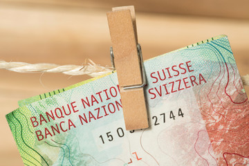 Ein 50 Schweizer Franken Geldschein an einer Wäscheleine mit Wäscheklammer