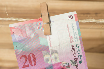 Ein 20 Schweizer Franken Geldschein an einer Wäscheleine mit Wäscheklammer