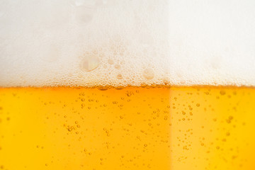 Pouring beer with bubble froth in glass for background on front view 