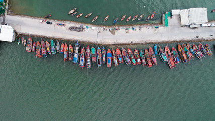 Aerial drone top view of tour and fishing boats morred on the pier in Pattaya, Thailand © stryjek