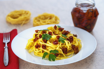 spaghetti with sun-dried red tomatoes and parsley close-up