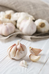 Garlic bulb with garlic cloves on white rustic wood.