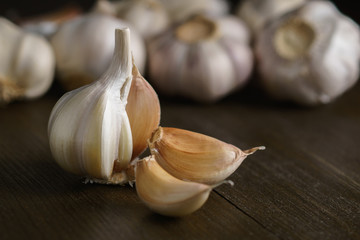 Garlic bulb with garlic cloves on dark wood.