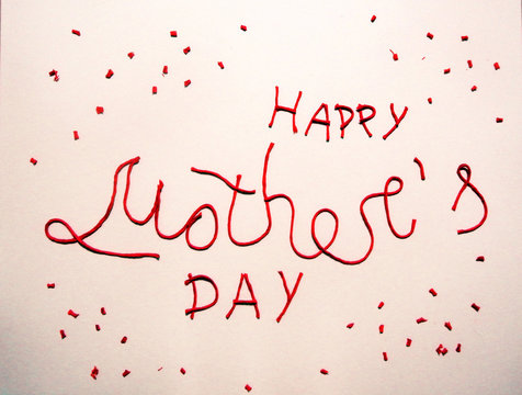 picture of the inscription Happy Mother's day made by red threads on beige background. Hand lettering. Cute text for postcard.