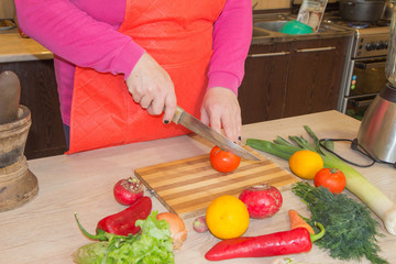 woman hands cutting vegetables on kitchen blackboard. Healthy food. Woman preparing vegetables