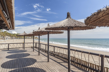Mediterranean sea, spring sunny day, baech and umbrella terrace bar, Costa Dorada, Catalonia, Spain.