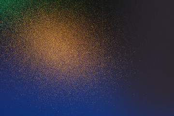 Abstract shiny reflections of colorful lights on a grainy glass surface.