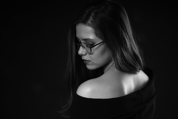 Naklejka premium black and white photo of a girl in glasses / classic glasses girl portrait of a strict businesswoman concept