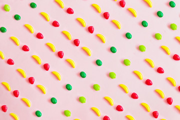 Food pattern of sweet toys in the form of fruit, banana, lemon, strawberry, orange, abstract pink and purple background 