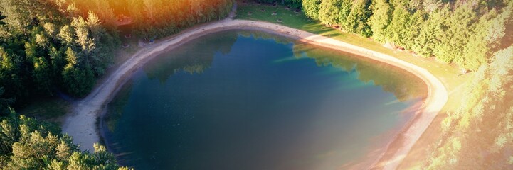 Turquoise pool surrounded with dense green forest