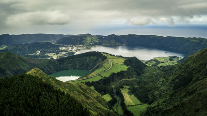Fototapeta na wymiar Aerial view on scenic landscape of volcanic lake Sete Cidades and green fields around it. Special shape of ground. Atlantic ocean on background. Azores islands, Sao Miguel, Portugal.