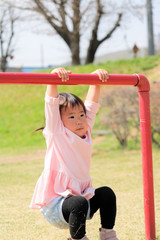 Fototapeta premium 遊具にぶら下がる女の子