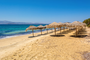 Parasols on Agia Anna beach, one of the best organized beaches of Naxos. Cyclades Islands, Greece. - obrazy, fototapety, plakaty