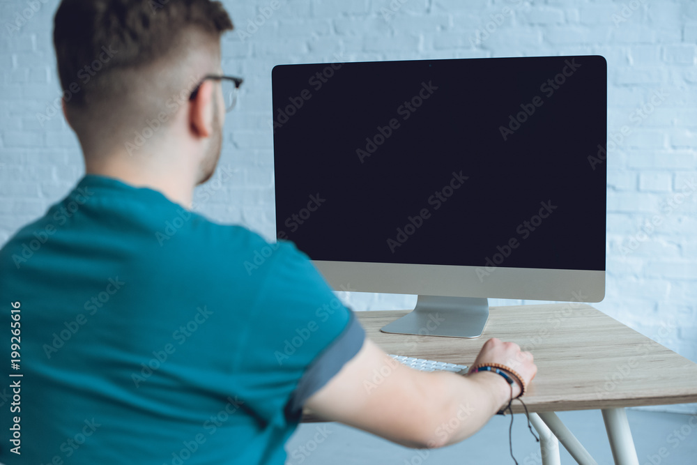 Poster rear view of man looking at computer screen on table
