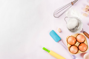 Obraz na płótnie Canvas Ingredients and utensils for cooking baking egg, flour, sugar, whisk, rolling pin, on light pink background, top view copy space