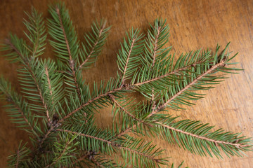 Christmas tree branch on wooden table from above