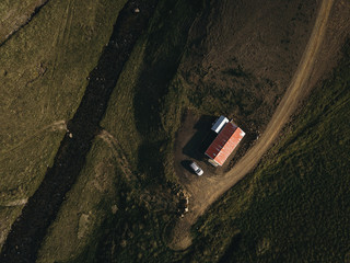 Aerial view of house and car parked nearby field