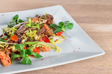 beef slices in spicy sauce with vegetables, Peking cabbage and corn salad