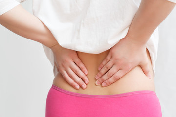 the woman grabbed her waist with two hands. the concept of lower back pain