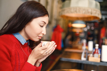 woman drinking coffee or tea in the morning at restaurant
