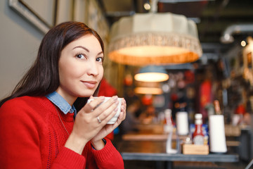 woman drinking coffee or tea in the morning at restaurant