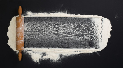 background with flour sprinkled on a black table with a rolling pin on the side - 199269272