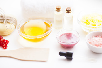Natural herbal skin care products. Top view ingredients honey, sea salt, berries, oil and soap on the white background. Medical care, spa, beauty, health concept. 
