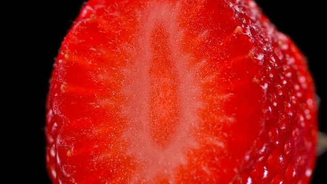 ripe, juicy strawberry cut slowly rotates, close-up