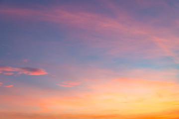 the sky at sunset with purple orange and blue hues. traces of aircraft and light clouds