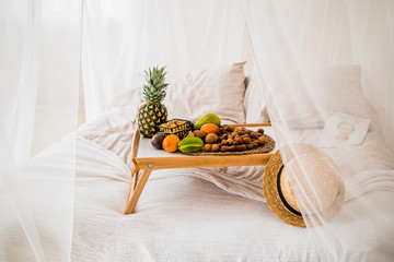 tropical fruits on the tray on the bed