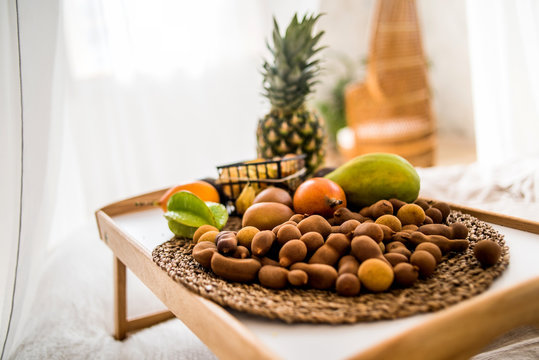 tropical fruits on the tray on the bed