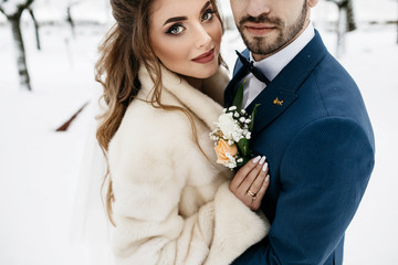 Wedding couple, bride and groom in winter holding hands together