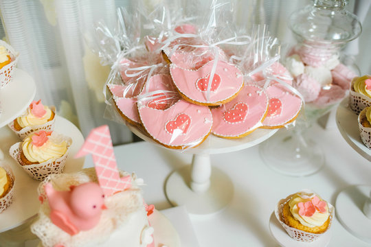 Catering for birthday party. Closeup of sweet cute pink desserts served on table at home or restaurant interior. First year of life of little baby girl celebration. Horizontal color photo.