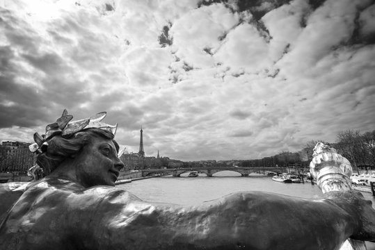 Fototapeta Antique statue on bridge Alexandre III, the river Seine and the Eiffel tower, Paris, France, black and white photography